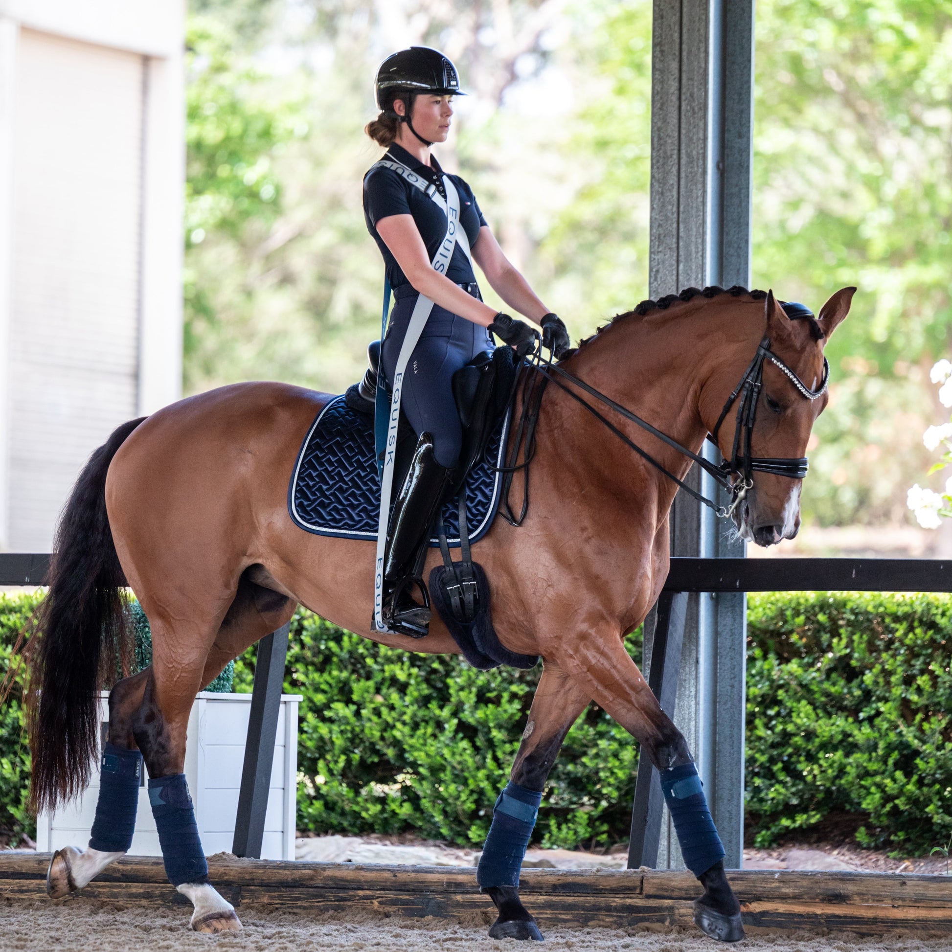Person riding a horse in an outdoor equestrian setting